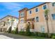 Beautiful two-story townhome with beige and brown color scheme, manicured landscaping, and sunny blue skies at 316 Trieste Loop, Lake Mary, FL 32746