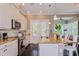 Well-lit kitchen featuring a central island with barstool seating, modern appliances, and patio access at 316 Trieste Loop, Lake Mary, FL 32746