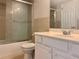 Bathroom features a shower with glass doors, neutral tiles, and white vanity with sink at 3772 Idlebrook Cir # 210, Casselberry, FL 32707