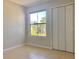 Bedroom showcasing neutral walls, tiled floors, a window and closet with folding doors at 3772 Idlebrook Cir # 210, Casselberry, FL 32707