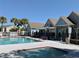 Community swimming pool featuring lounge chairs, umbrellas, and nearby apartment buildings at 3772 Idlebrook Cir # 210, Casselberry, FL 32707