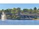 Beautiful lakeside community clubhouse featuring water fountain and palm trees with community pool and seating at 413 Summit Ridge Pl # 115, Longwood, FL 32779