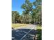 Inviting community entrance featuring lush landscaping and a street lined with mature trees at 413 Summit Ridge Pl # 115, Longwood, FL 32779
