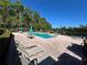 Community swimming pool with lounge chairs and tables on brick patio deck at 413 Summit Ridge Pl # 115, Longwood, FL 32779