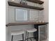 Close-up of bar area with shelving and decor and stools in a modern design at 4321 Lana Avenue, Davenport, FL 33897