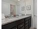 Bathroom featuring dual sink vanity with granite countertop and framed wall art at 4321 Lana Avenue, Davenport, FL 33897