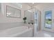 Bright bathroom boasting a soaking tub, glass shower and views of outdoor pool through the glass door at 4321 Lana Avenue, Davenport, FL 33897