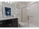 Bathroom featuring a granite countertop, dark wood cabinets, and a glass-enclosed shower, offering a clean design at 4321 Lana Avenue, Davenport, FL 33897