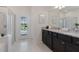 Bright bathroom featuring a dual sink vanity with granite countertop and a glass shower with view to outdoor pool at 4321 Lana Avenue, Davenport, FL 33897