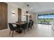 Dining area with a wooden table and gray upholstered chairs, complemented by modern lighting and a sliding glass door at 4321 Lana Avenue, Davenport, FL 33897