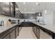 Modern kitchen featuring dark wood cabinets, granite countertops, stainless steel appliances, and an island with ample counter space at 4321 Lana Avenue, Davenport, FL 33897