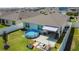 An aerial view of the backyard featuring a sandbox, fire pit, above ground pool and a covered patio at 460 Lily Ln, Davenport, FL 33837