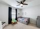 A charming bedroom with a ceiling fan, a neutral palette, and a daybed featuring built-in drawers at 460 Lily Ln, Davenport, FL 33837