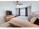 Bedroom features a large bed, neutral decor, ceiling fan, and dresser with a flat screen television at 460 Lily Ln, Davenport, FL 33837