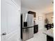 Modern kitchen with stainless steel refrigerator and dark cabinetry, adjacent to dining area at 460 Lily Ln, Davenport, FL 33837