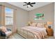 Bright bedroom features charming decor, a ceiling fan, and large window that brings in ample natural light at 4955 Castle E St, Kissimmee, FL 34758