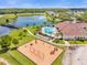 An aerial view of community amenities features a pool, playground, lake, and a walking path at 4955 Castle E St, Kissimmee, FL 34758