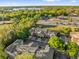 Aerial view showcasing townhomes near a highway and lake, surrounded by lush trees at 5020 Ashford Falls Ln, Oviedo, FL 32765