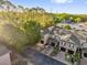 Aerial view of townhomes with attached garages, surrounded by trees and a road at 5020 Ashford Falls Ln, Oviedo, FL 32765