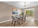 Elegant dining room featuring a glass table, seating for six, stylish lighting, and access to patio at 5020 Ashford Falls Ln, Oviedo, FL 32765