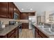 Modern kitchen featuring dark wood cabinets, stainless steel appliances, and a breakfast bar with seating at 5020 Ashford Falls Ln, Oviedo, FL 32765