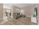 Cozy living room with comfortable gray sofa, wood-look floors, and open view to the kitchen at 5020 Ashford Falls Ln, Oviedo, FL 32765