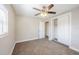 A bedroom with a ceiling fan, carpeted floor, closet, and a window with blinds at 5210 Grandview Dr, Orlando, FL 32808