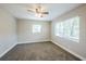 A cozy bedroom with neutral paint, carpeted floor, ceiling fan, and natural light from two windows at 5210 Grandview Dr, Orlando, FL 32808