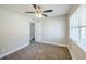 Bedroom features neutral carpet, ceiling fan, and light-filled window at 5210 Grandview Dr, Orlando, FL 32808