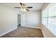 A cozy bedroom with neutral walls, carpeting, a ceiling fan, and a window with blinds at 5210 Grandview Dr, Orlando, FL 32808