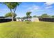 Large backyard with green lawn, shed, swing set, and dark wooden fence at 536 Ellerbe Way, Lakeland, FL 33801