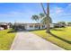 Charming single-story home featuring a well-maintained lawn and long driveway on a sunny day at 536 Ellerbe Way, Lakeland, FL 33801