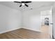 Bright bedroom with sleek ceiling fan and wood-look flooring, adjacent to a modern, white kitchen at 5790 Crystal Beach Rd, Winter Haven, FL 33880