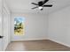 Bedroom featuring wood flooring, ceiling fan, and a window providing natural light and an outdoor view at 5790 Crystal Beach Rd, Winter Haven, FL 33880