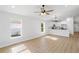 Bright living room with wood flooring and a view of the kitchen with stainless steel appliances and white cabinets at 5790 Crystal Beach Rd, Winter Haven, FL 33880