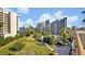 Scenic aerial view of lush landscaping, community pool, and high-rise condominiums under a partly cloudy blue sky at 6165 Carrier Dr # 3512, Orlando, FL 32819