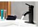 A modern black faucet pours water into a white sink with a black hand towel at 6165 Carrier Dr # 3512, Orlando, FL 32819