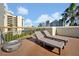 Rooftop deck featuring two lounge chairs, a fire pit, and views of the cityscape under a partly cloudy blue sky at 6165 Carrier Dr # 3512, Orlando, FL 32819