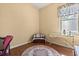 Bedroom with wood floors featuring rug, trunk and ironing board next to the window at 6651 Sylvan Woods Dr, Sanford, FL 32771