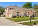 Beautiful peach colored single-Gathering home featuring a well-kept lawn and an attached two car garage at 6651 Sylvan Woods Dr, Sanford, FL 32771