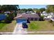 Single-story home with a driveway, a large front and back yard with neighborhood in the background at 7717 Pineapple Dr, Orlando, FL 32835