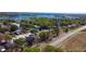 Aerial view showcasing a neighborhood with tree-lined streets near a serene lake at 7717 Pineapple Dr, Orlando, FL 32835