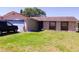 Cozy single-story home featuring stone accents, blue garage door, and spacious front lawn at 7717 Pineapple Dr, Orlando, FL 32835