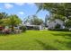 Expansive backyard featuring lush lawn, mature trees, tropical landscaping and a view of the home at 801 Silver Dr, Orlando, FL 32804