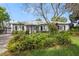 Charming single-story home featuring lush landscaping, a gray exterior, shuttered windows, and a welcoming entrance at 801 Silver Dr, Orlando, FL 32804