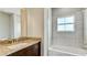 Bathroom featuring granite countertops, a dark vanity, and a tiled shower and bath combination at 8544 Magnificent Ln, Groveland, FL 34736