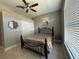 Bedroom features include a dark metal bed frame, tile floors, a ceiling fan, and natural light from the window at 938 Cherry Valley Way, Orlando, FL 32828