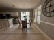 Well-lit dining room features tile flooring, a glass table, and a view of the kitchen at 938 Cherry Valley Way, Orlando, FL 32828