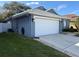 Side view of a cozy home with a two-car garage, vibrant green grass and freshly painted exterior at 938 Cherry Valley Way, Orlando, FL 32828