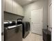 Well-equipped laundry room with tile floors, cabinets, and washer and dryer for convenient laundry tasks at 938 Cherry Valley Way, Orlando, FL 32828